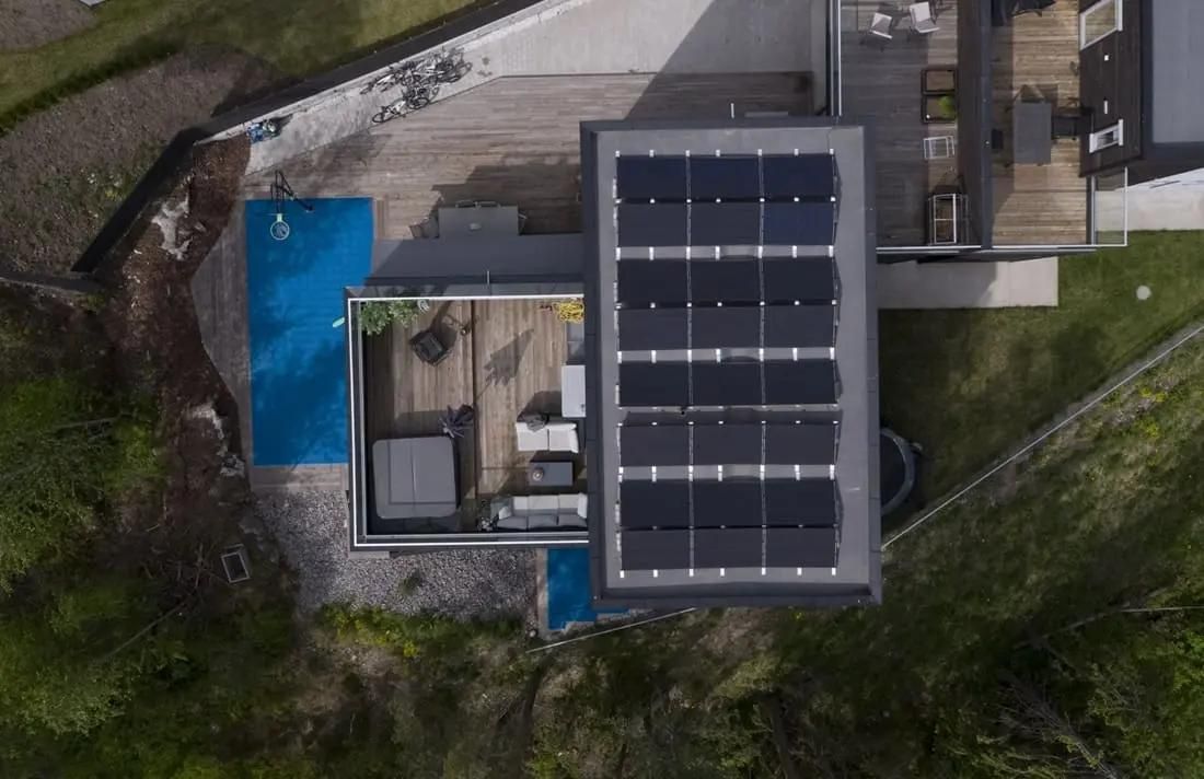 fågelvy över villa med solpaneler på platt tak