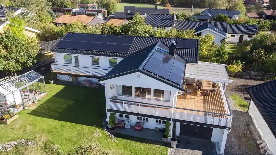 stort vitt hus med solpaneler på taket