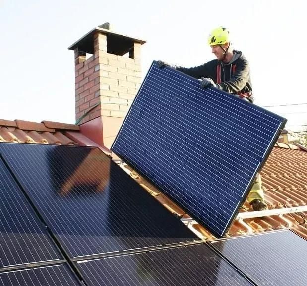 Installatör av solpaneler som är på taket och jobbar