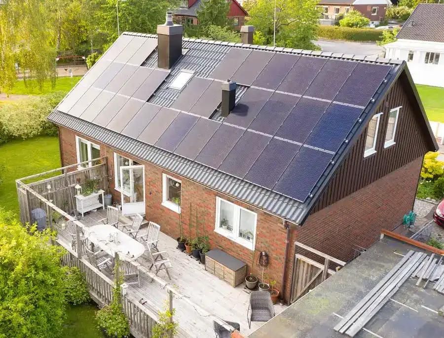 tegelhus med svarta solceller på taket