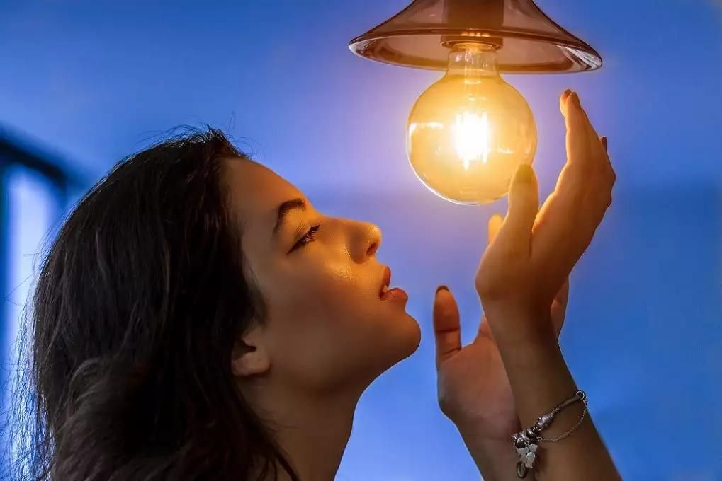 Photo by Marcelo - från pexels. Tjej som tittar på en tänd lampa