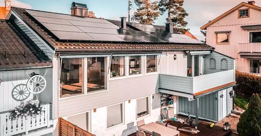 Svarta solpaneler på taket som har fästs runt skorstenarna